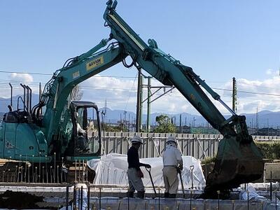 重機が土を入れ、人が平らにならします